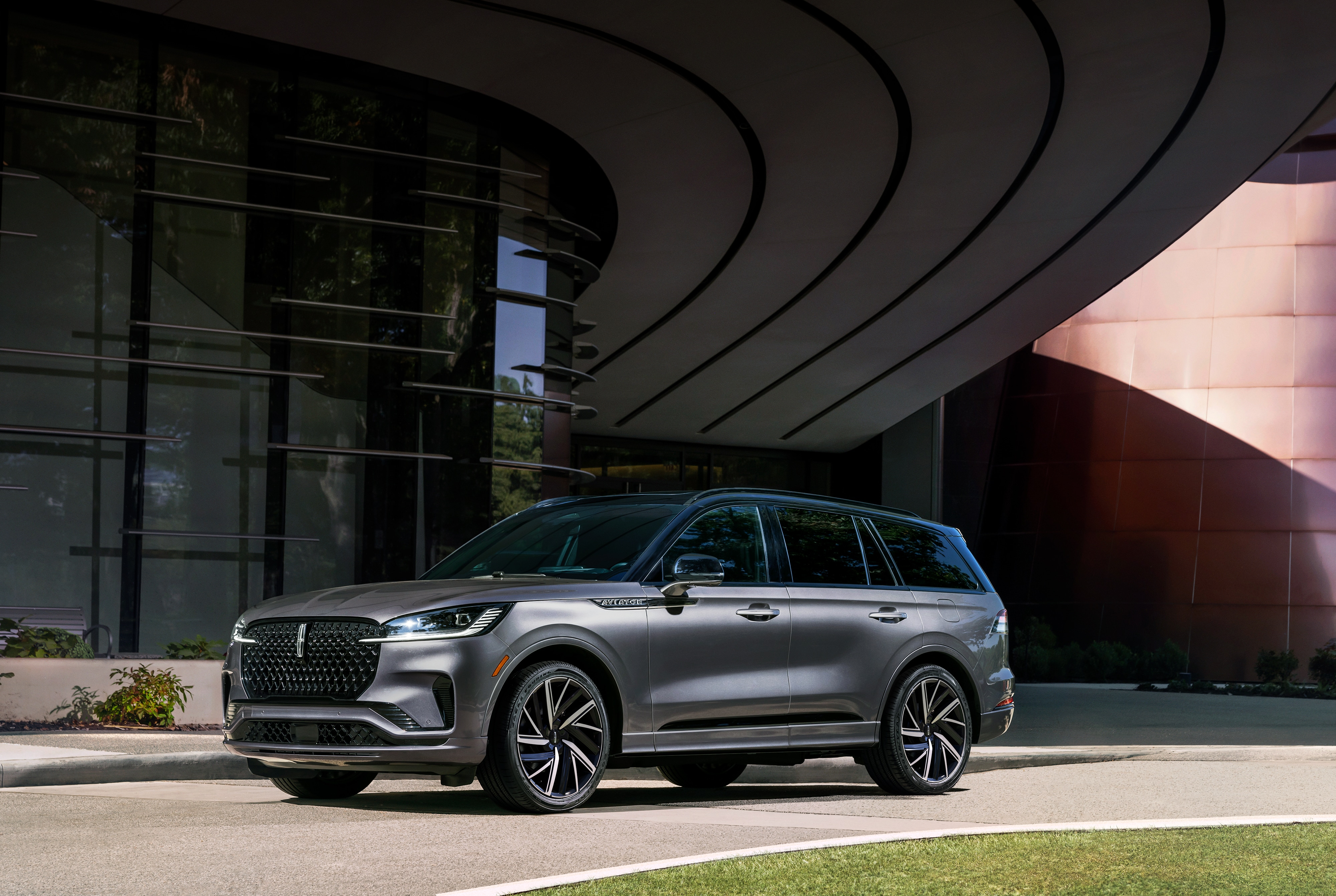 A 2026 Lincoln Aviator<sup>®</sup> SUV is being driven hands-free on a highway near a forest.